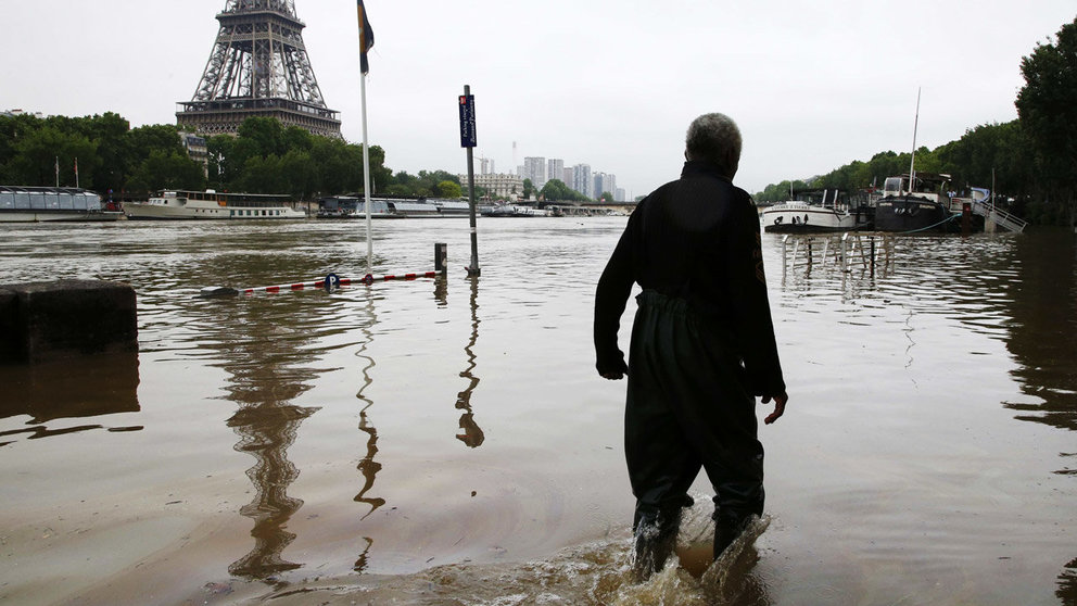 Un hombre camina por una calle inundada cerca de la Torre Eiffel, en París. Pascal Rossignol